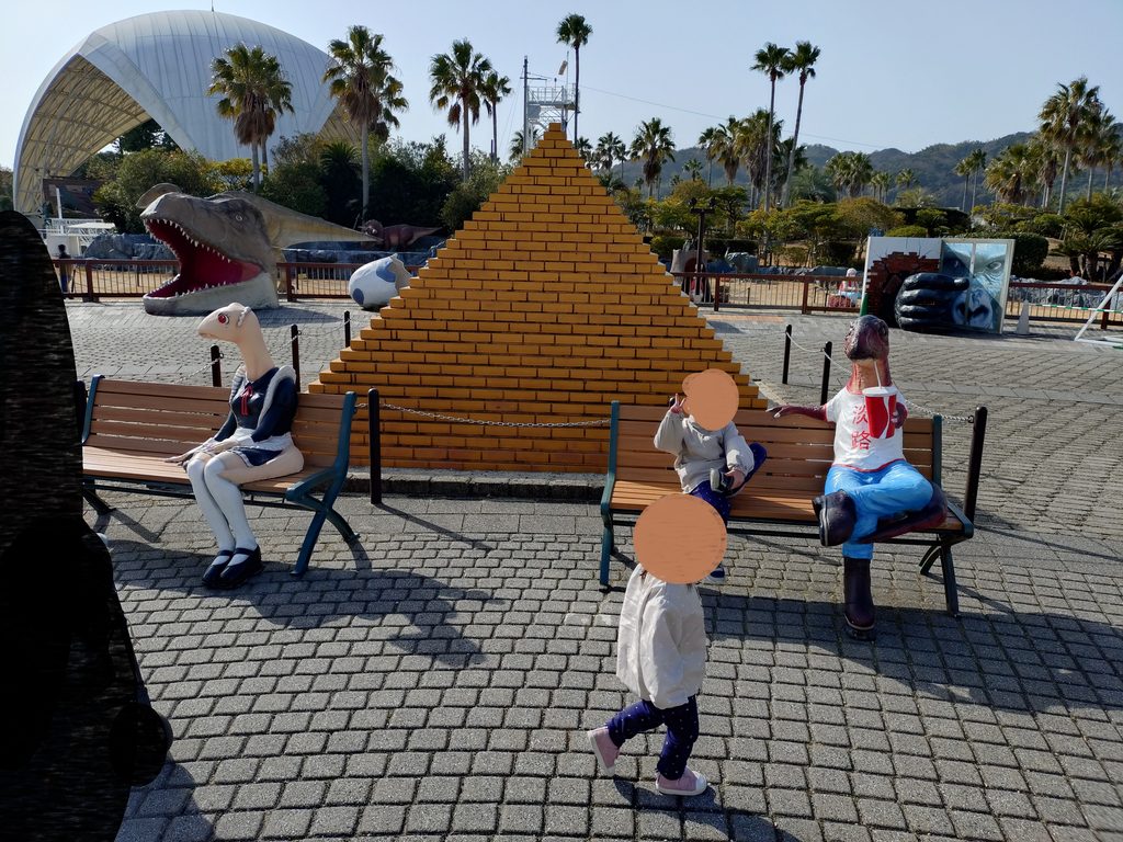 ピラミッドをバックに人化した恐竜がベンチに座っているカオスな空間。恐竜の隣に座って記念撮影する人も多い